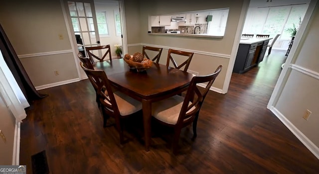 dining room with dark wood finished floors and baseboards