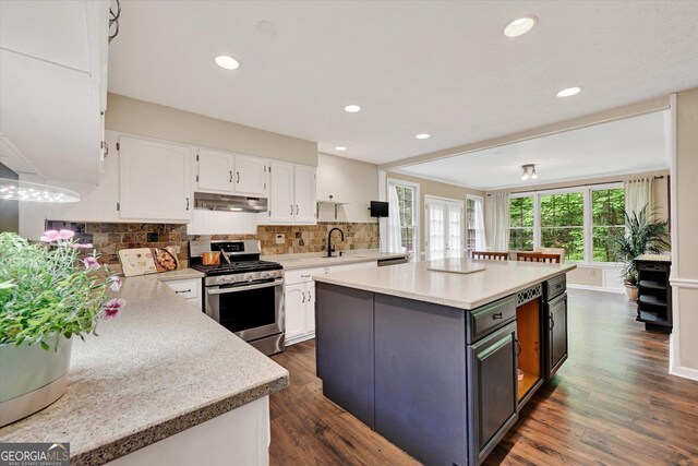 kitchen featuring stainless steel gas range, under cabinet range hood, white cabinets, light countertops, and recessed lighting