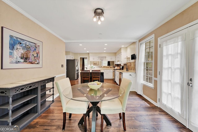 dining room with baseboards, ornamental molding, dark wood finished floors, and recessed lighting