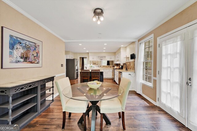 dining room with baseboards, ornamental molding, dark wood finished floors, and recessed lighting