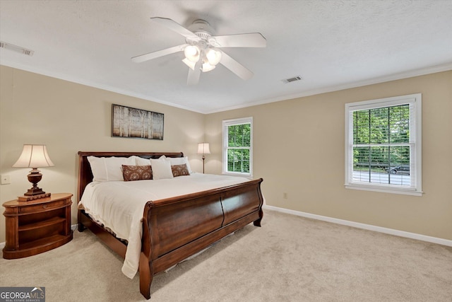 bedroom featuring light carpet, ornamental molding, baseboards, and ceiling fan
