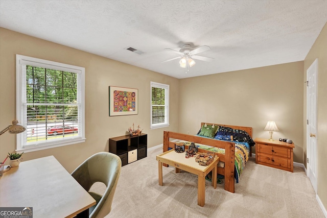 carpeted bedroom featuring multiple windows, baseboards, ceiling fan, and a textured ceiling