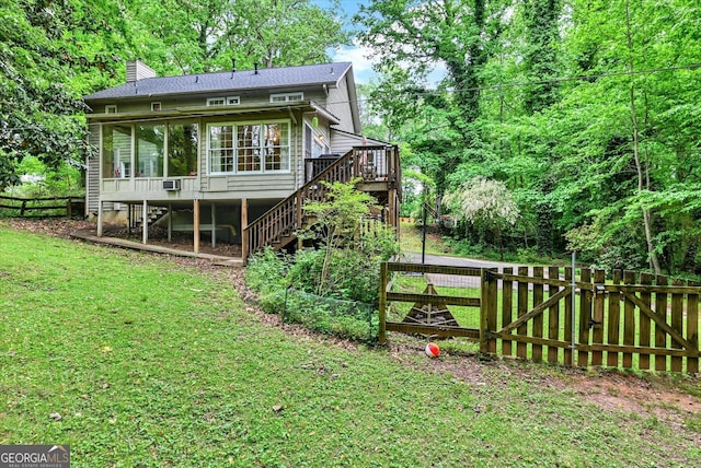 rear view of property with stairs, a chimney, a deck, a sunroom, and a gate