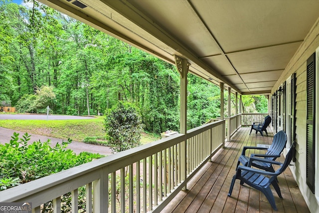 deck featuring a porch and a view of trees