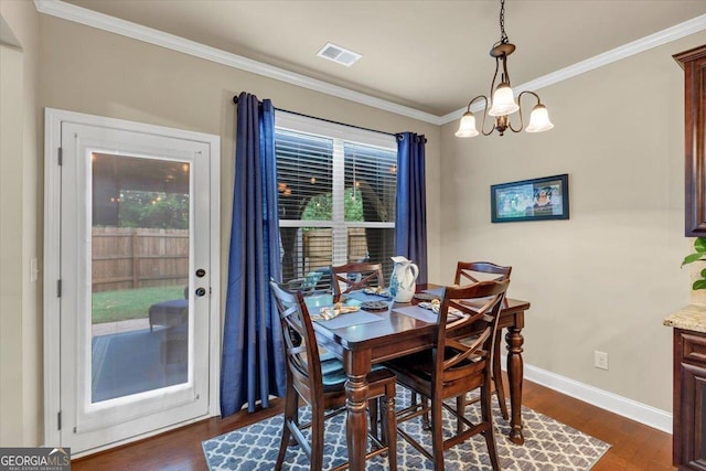 2376 Roberts View Trl, Buford, GA 30519 - dining space featuring baseboards, dark wood-style flooring, an inviting chandelier, visible vents, and crown molding