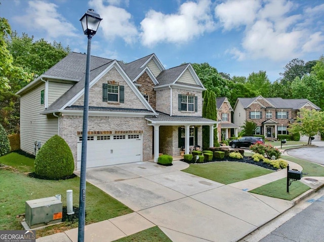 2376 Roberts View Trl, Buford, GA 30519 - craftsman house with an attached garage, a front lawn, concrete driveway, a porch, and brick siding