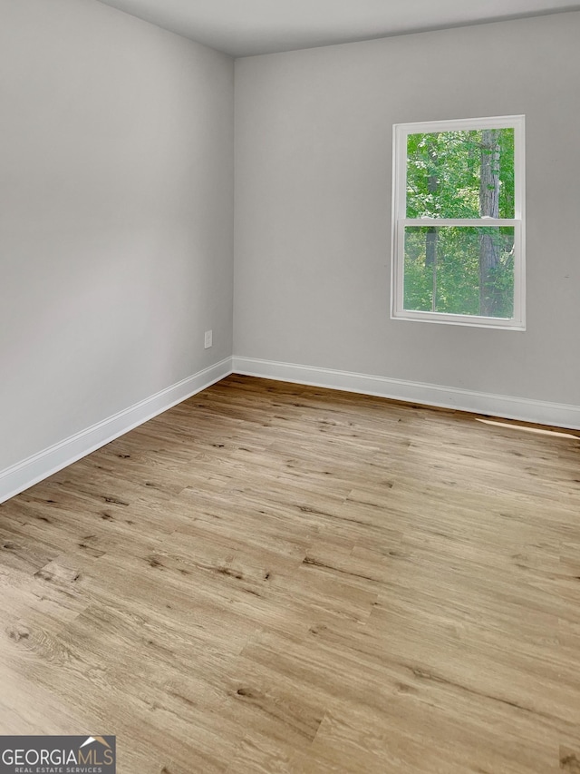empty room with baseboards and wood finished floors