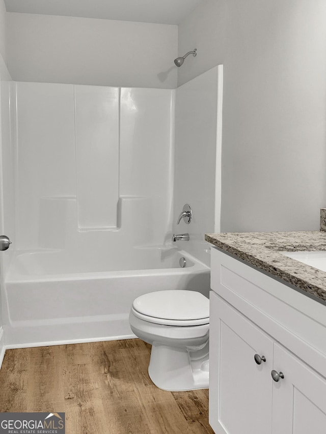 full bathroom with toilet, bathtub / shower combination, wood finished floors, and vanity