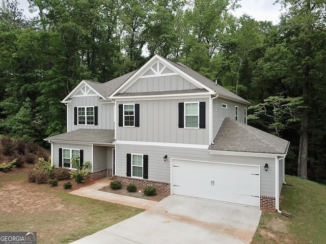 craftsman house featuring a front yard, a shingled roof, board and batten siding, concrete driveway, and an attached garage