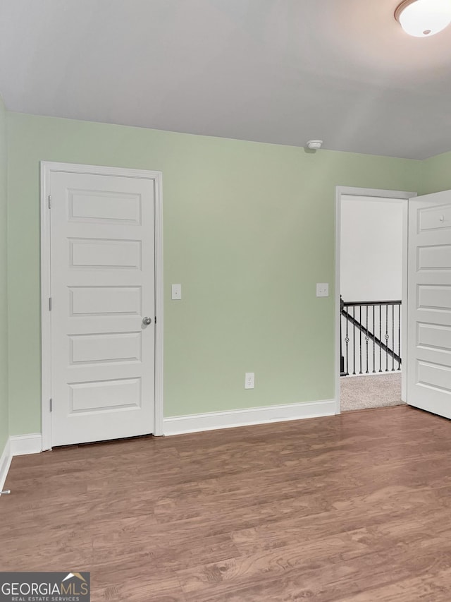 empty room with baseboards and wood finished floors