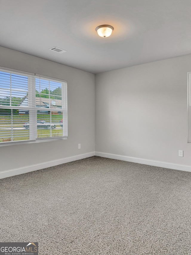 unfurnished room featuring visible vents and baseboards