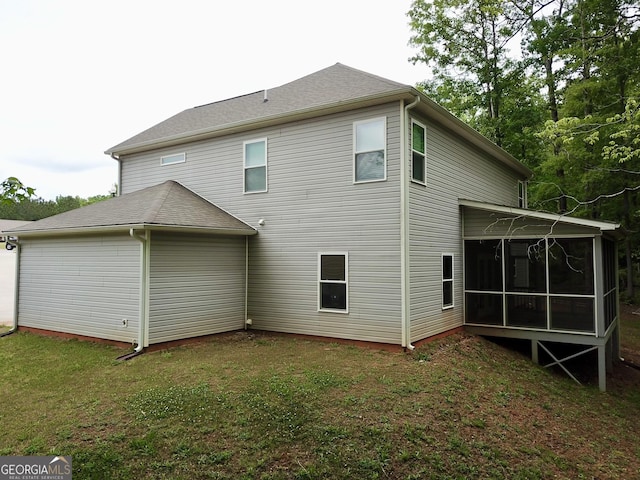 back of property featuring a sunroom and a yard