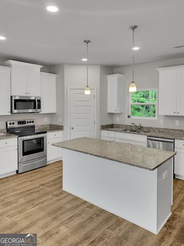 kitchen featuring appliances with stainless steel finishes, a sink, white cabinetry, recessed lighting, and visible vents