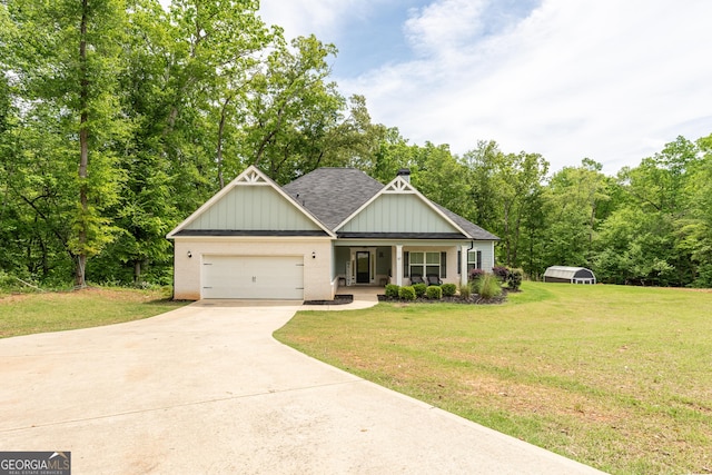 craftsman-style house with a front lawn, roof with shingles, concrete driveway, an attached garage, and a porch