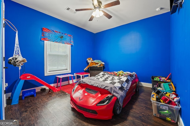 bedroom featuring visible vents, a ceiling fan, baseboards, and wood finished floors