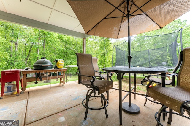view of patio with area for grilling and a trampoline