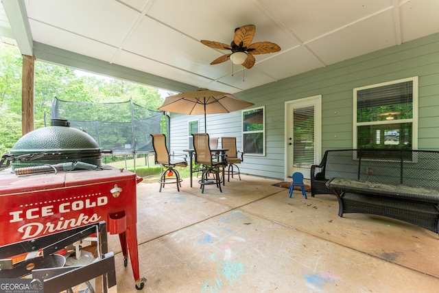 view of patio / terrace with a trampoline, an outdoor hangout area, grilling area, outdoor dining area, and a ceiling fan