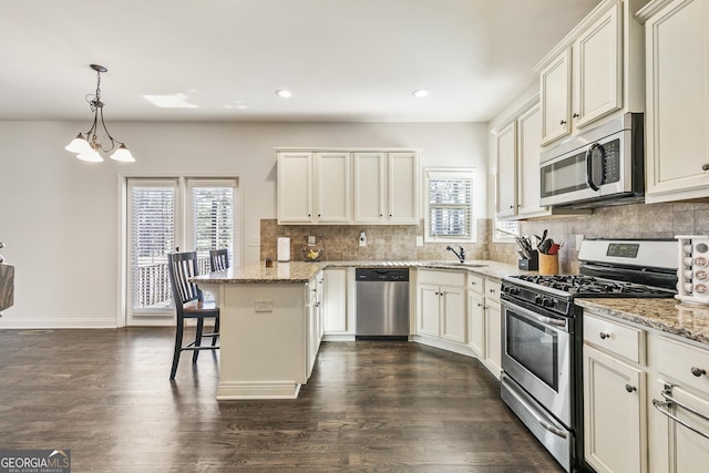 97 Fieldstone Ln, Dallas, GA 30132 - kitchen featuring appliances with stainless steel finishes, a sink, a peninsula, a kitchen breakfast bar, and tasteful backsplash