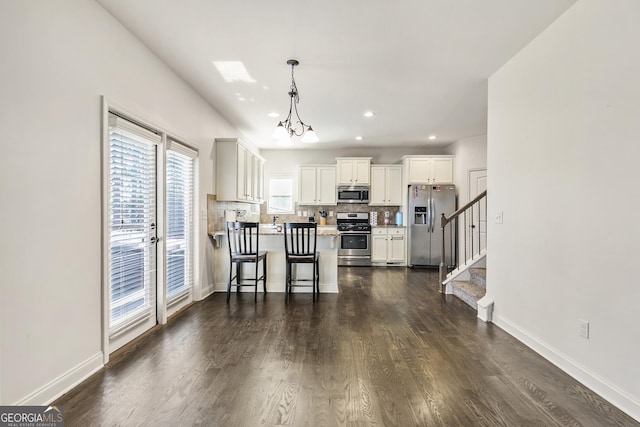 97 Fieldstone Ln, Dallas, GA 30132 - kitchen featuring appliances with stainless steel finishes, tasteful backsplash, a peninsula, light countertops, and dark wood-style flooring