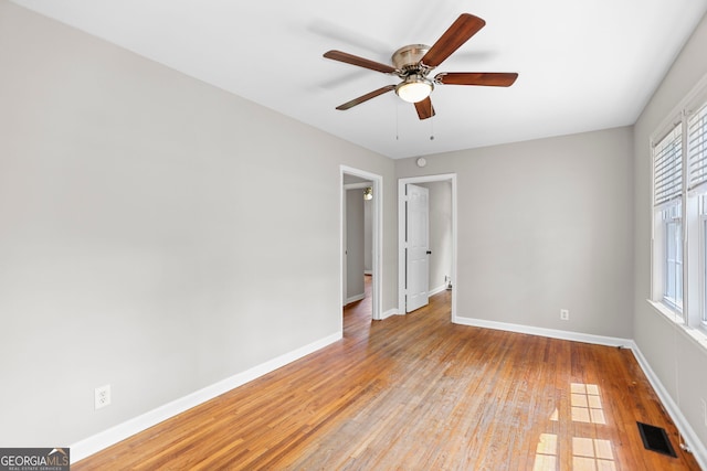 unfurnished room featuring a healthy amount of sunlight, baseboards, light wood-type flooring, and visible vents