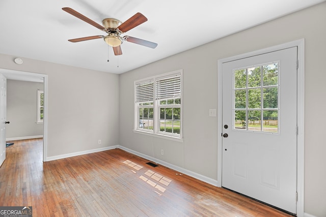 entryway with baseboards, a ceiling fan, light wood-type flooring, and visible vents