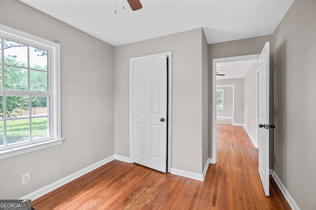 unfurnished bedroom with wood-type flooring, baseboards, and ceiling fan