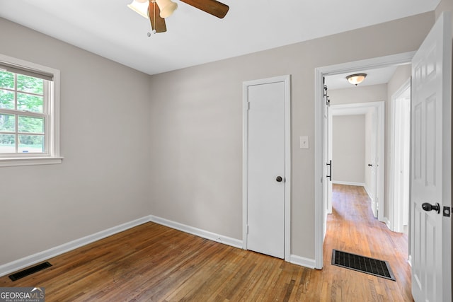 spare room featuring a ceiling fan, baseboards, visible vents, and light wood-type flooring