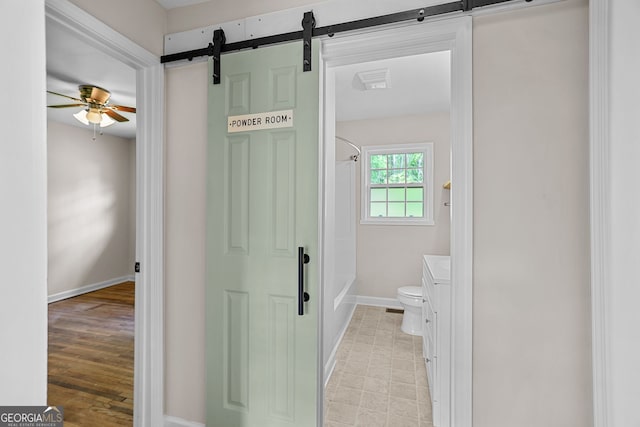 full bath featuring ceiling fan, shower / bath combo, vanity, toilet, and baseboards