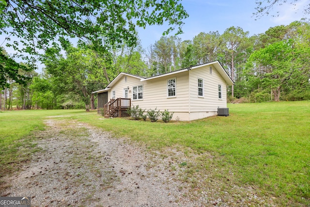 exterior space featuring driveway, central AC, a yard, and crawl space