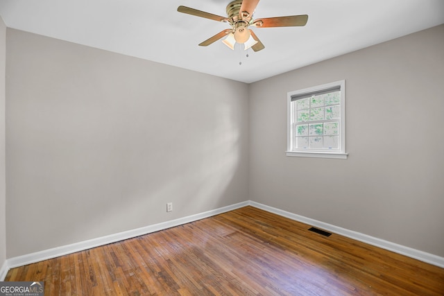 empty room with baseboards, ceiling fan, and visible vents