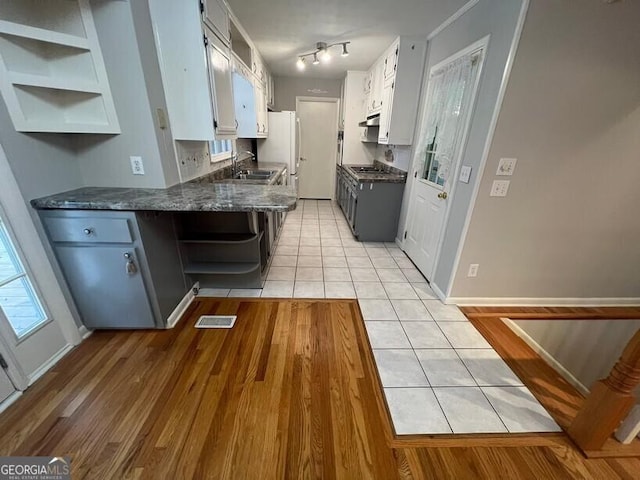 kitchen featuring a sink, open shelves, visible vents, and light tile patterned floors