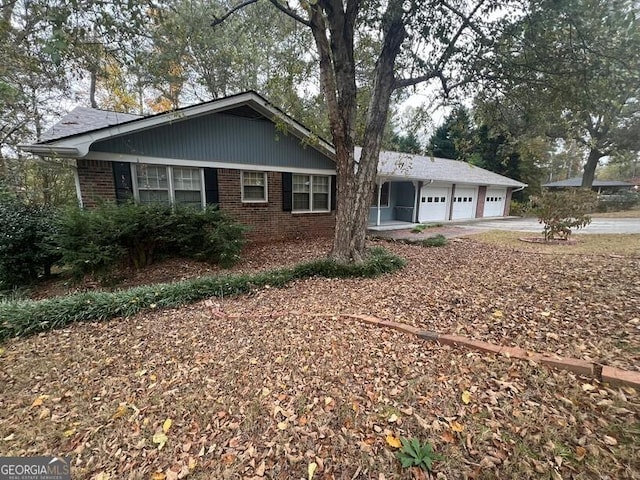 view of front of home with an attached garage, concrete driveway, and brick siding