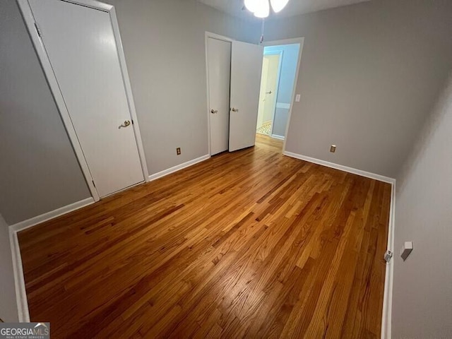 unfurnished bedroom with baseboards and wood finished floors