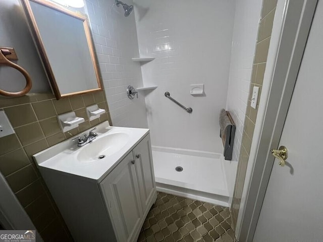 full bathroom with vanity, tile patterned flooring, a stall shower, and tile walls