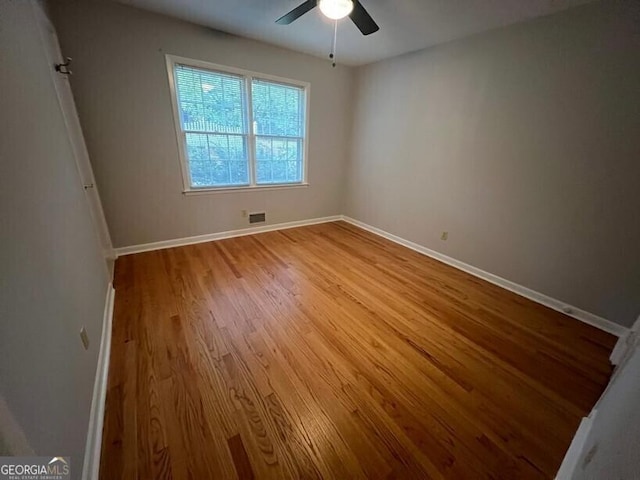 empty room with visible vents, baseboards, ceiling fan, and wood finished floors