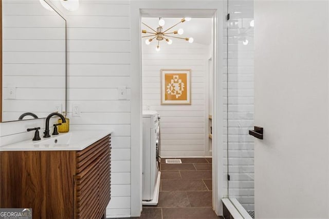 5785 Timberlane Ter, Sandy Springs, GA 30328 - full bathroom featuring vanity, wooden walls, tile patterned floors, a chandelier, and washing machine and clothes dryer