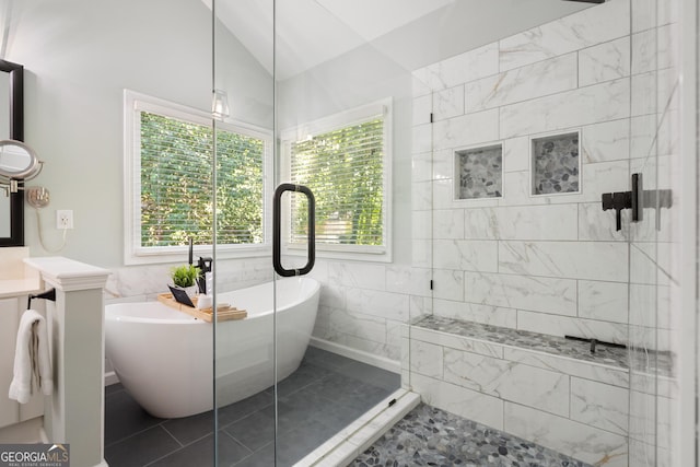 bathroom featuring a freestanding tub, lofted ceiling, tile walls, and a shower stall