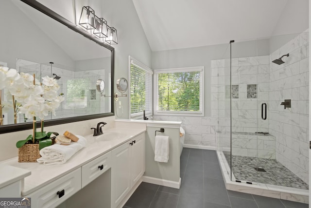 bathroom featuring vanity, tile patterned flooring, vaulted ceiling, and a stall shower