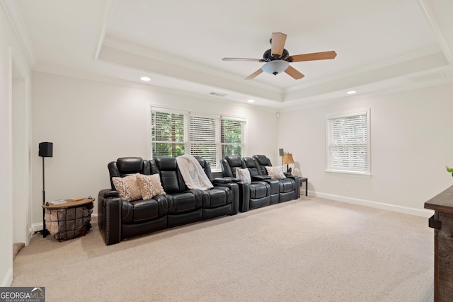home theater room with ornamental molding, a tray ceiling, carpet flooring, and ceiling fan