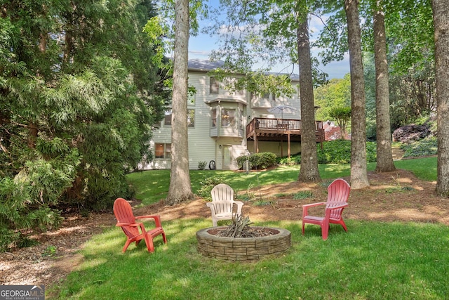 view of yard featuring a wooden deck and a fire pit