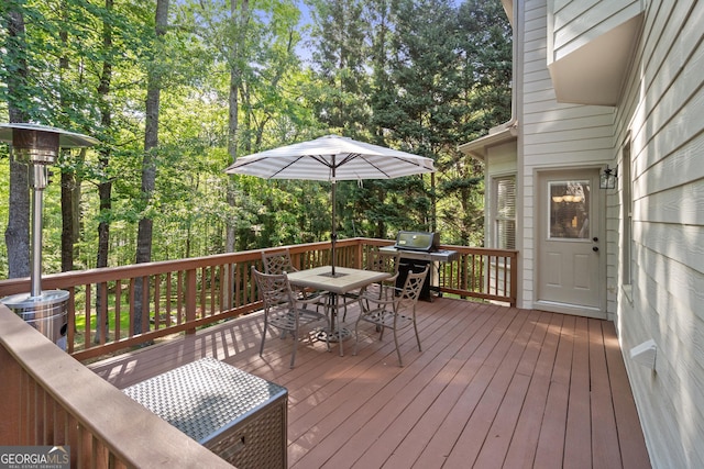 wooden deck with outdoor dining area and a grill