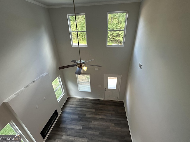 unfurnished living room with a ceiling fan, a healthy amount of sunlight, and dark wood-style floors