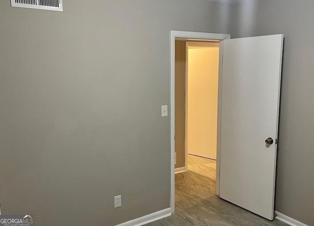 unfurnished bedroom with baseboards and marble look tiles