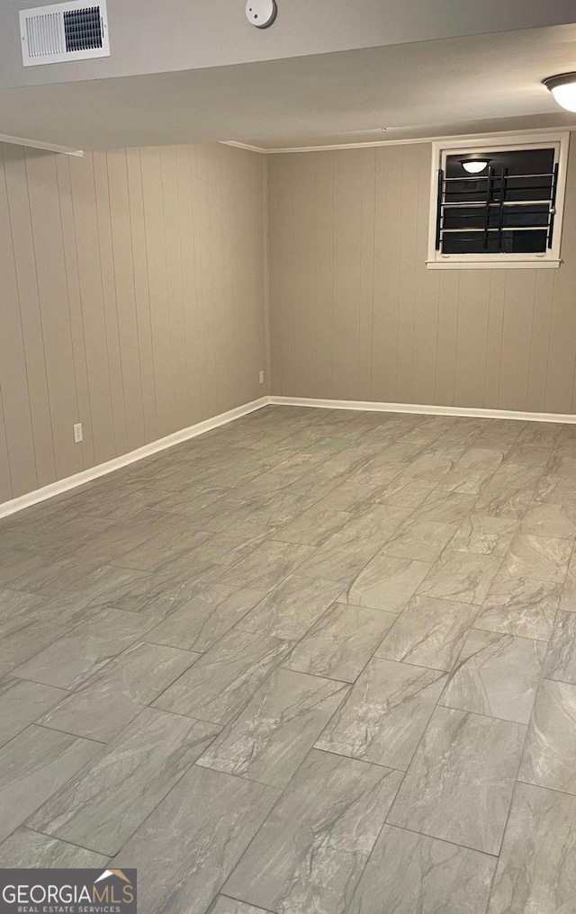 spare room with wood walls and marble finish flooring