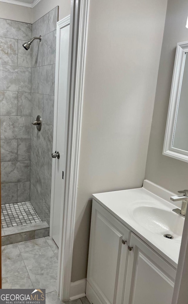 full bathroom featuring a tile shower and vanity