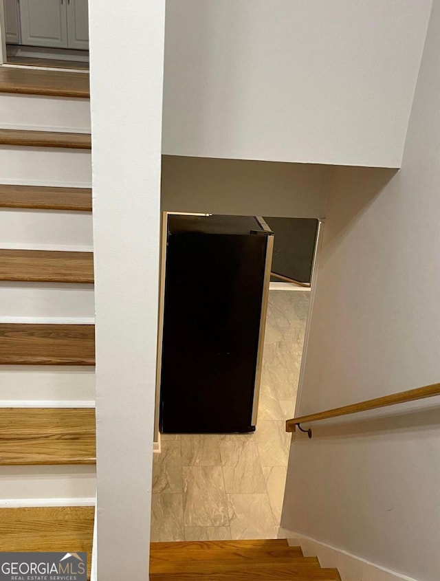 staircase with marble look tile flooring and baseboards