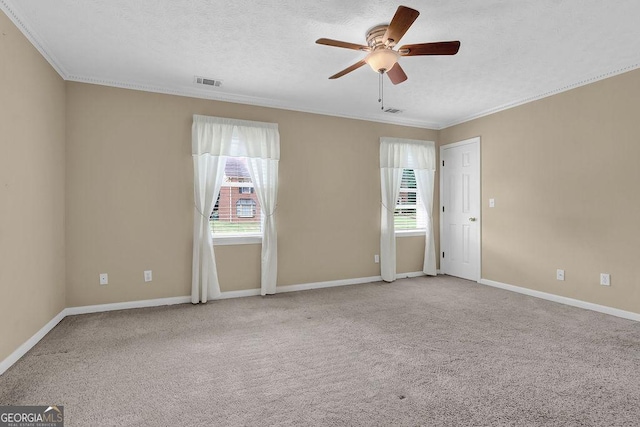 empty room featuring ceiling fan, crown molding, carpet, baseboards, and a textured ceiling