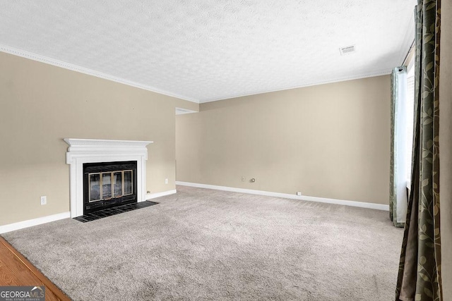 unfurnished living room with a textured ceiling, a fireplace with flush hearth, baseboards, crown molding, and carpet