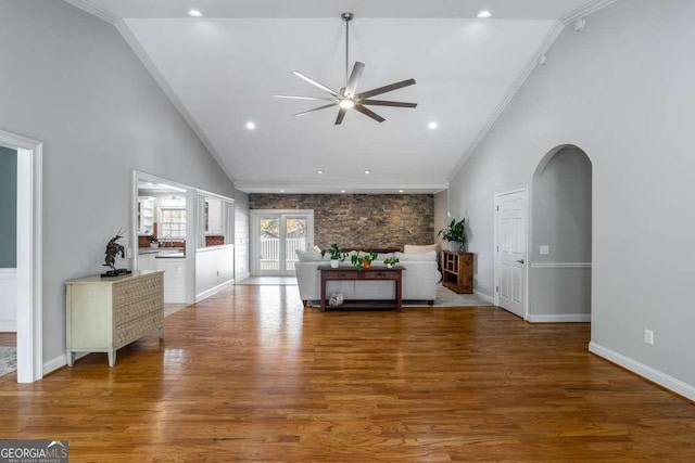 living area featuring crown molding, a ceiling fan, baseboards, and wood finished floors