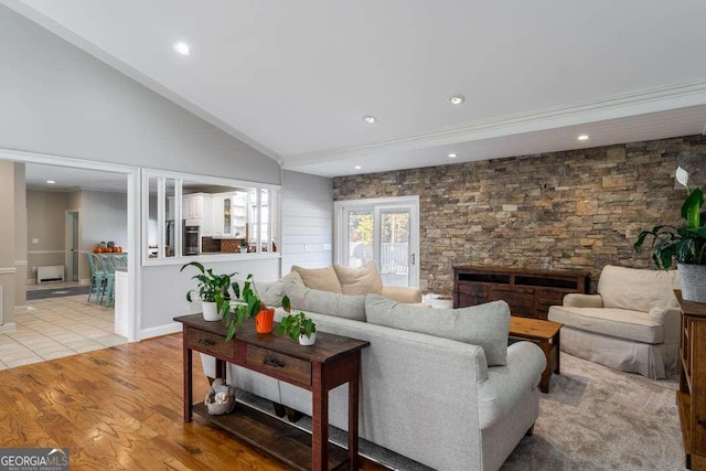 living room with recessed lighting, ornamental molding, light wood finished floors, and vaulted ceiling